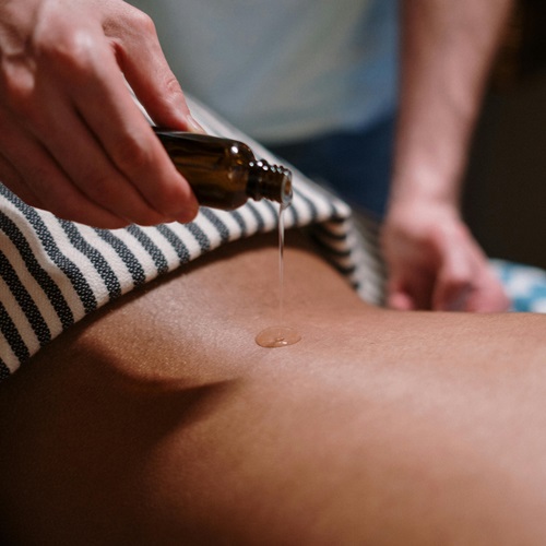 Man performing a sports massage on another man's back